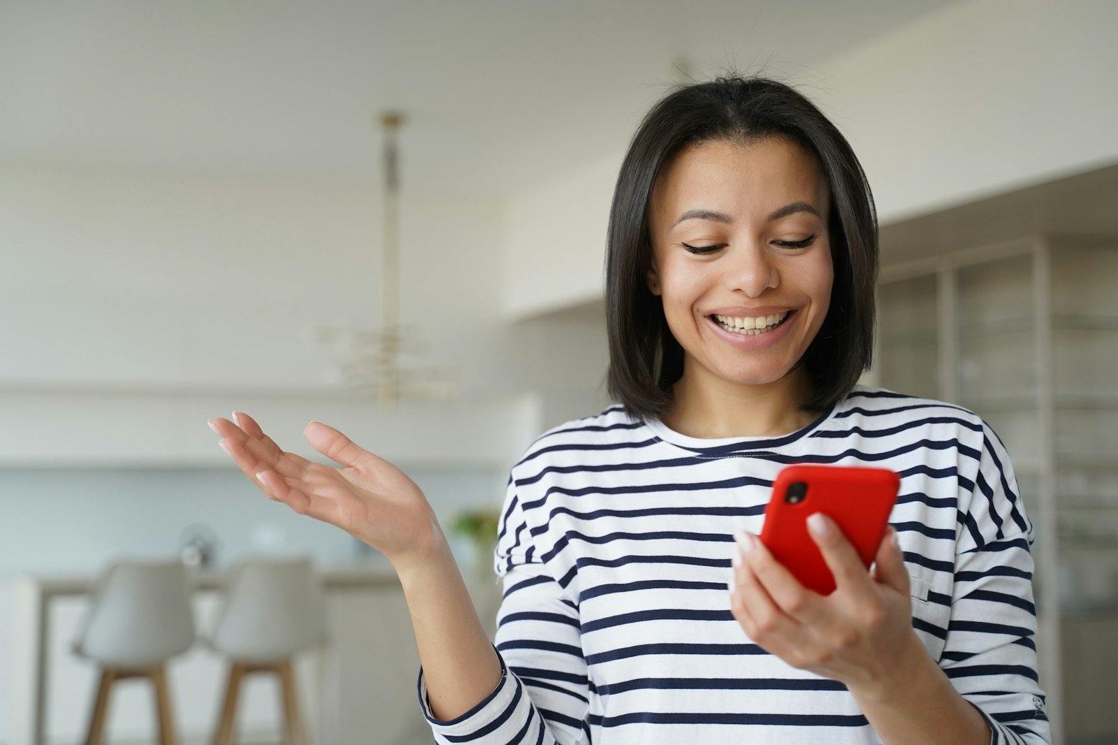 Female holding phone, reading good news message, happy with cashback, online store discount at home
